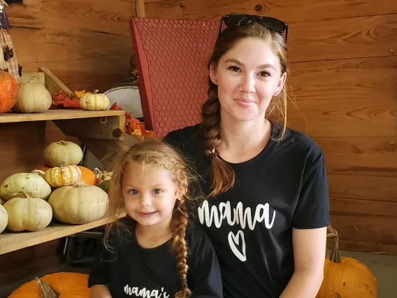 Photo of Amanda Vidimos and her daughter at a pumpkin patch