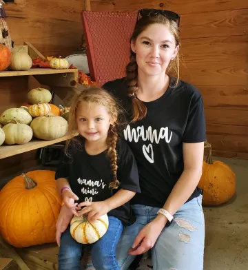 Photo of Amanda Vidimos and her daughter at a pumpkin patch